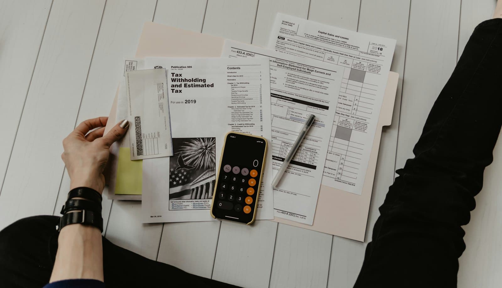 Justificatifs comptables, calculatrice et formulaires fiscaux sur un bureau